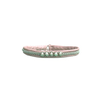 A thin hand braided bracelet made of soft leather with sterling silver beads and a reindeer antler button.