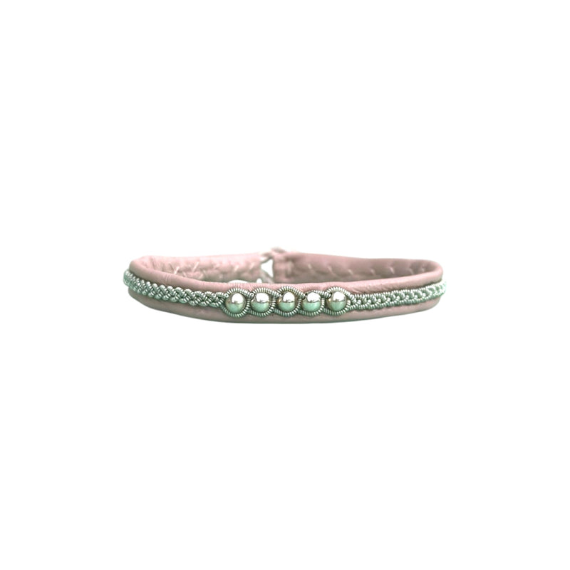 A thin hand braided bracelet made of soft leather with sterling silver beads and a reindeer antler button.