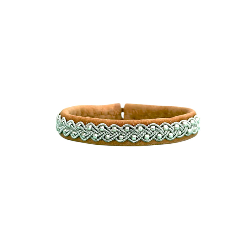 A hand braided bracelet with round silver beads and a reindeer antler button, made of naturally tanned reindeer leather from Swedish Lapland.
